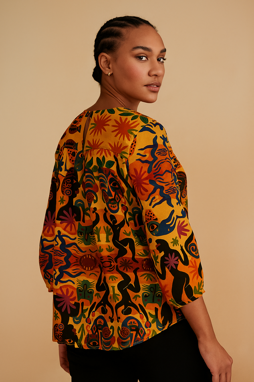 Blouse Tanéa portée de dos par une femme afro-métisse, illustrant la richesse de l’imprimé artistique et la coupe confortable à manches 3/4.