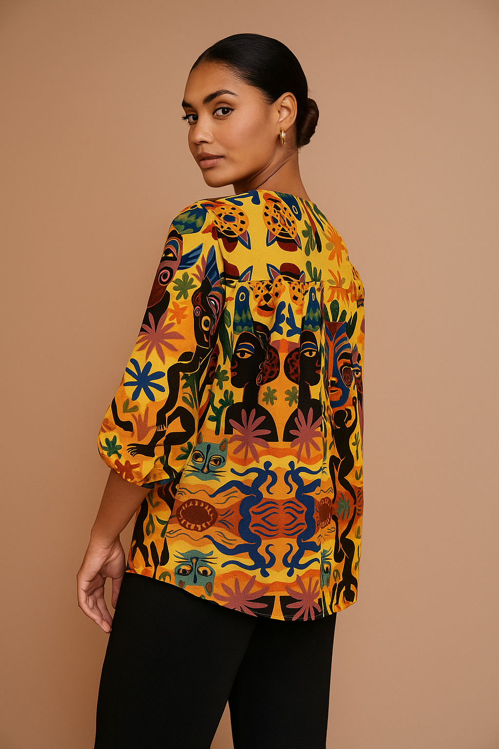 Blouse Tanéa portée de dos par une femme afro-métisse, illustrant la richesse de l’imprimé artistique et la coupe confortable à manches 3/4.