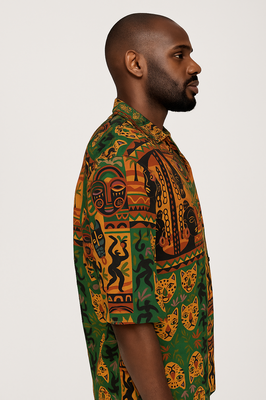 Mannequin homme afro élégant vu de profil gauche, portant la chemise Nzinga en coton satin bio, imprimé afro-luxe coloré avec motifs tribaux et félins.