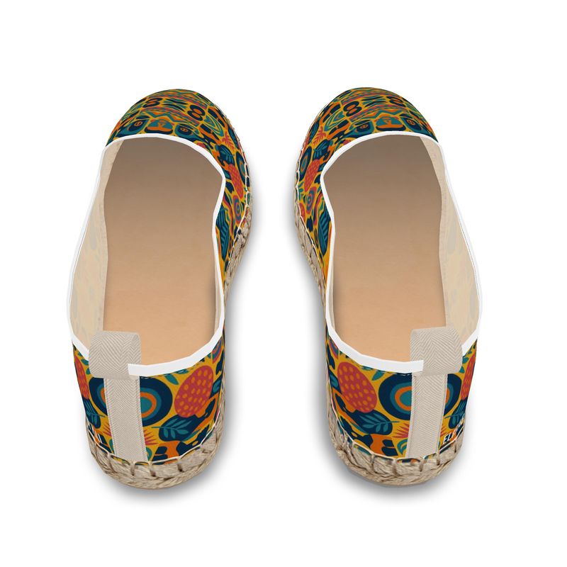 Paire d’espadrilles mocassins Zamaïa à imprimé artistique multicolore, fond jaune et bleu, semelle en corde naturelle, sur fond blanc.