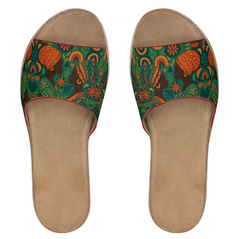 Paire de mules Dzanaï vue du dessus, imprimé all-over inspiré de l’art africain, avec visages féminins stylisés, fleurs et feuillages. Fond neutre pour présentation produit e-commerce.