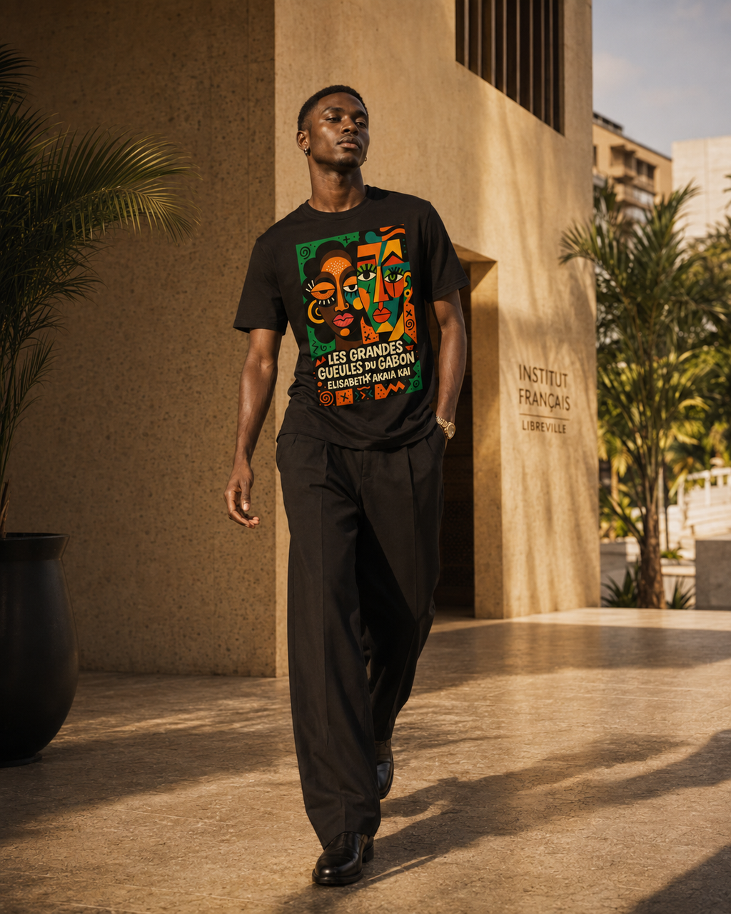 Homme africain en mouvement portant le t-shirt Les Grandes Gueules du Gabon dans une architecture contemporaine à Libreville au Gabon.