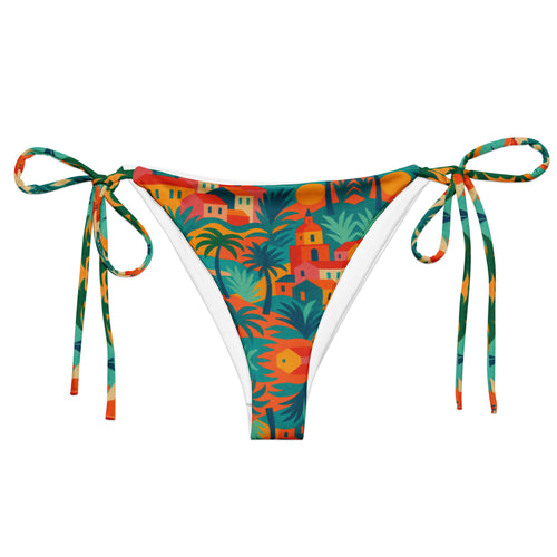Bas de bikini triangle luxe Rêve Riviera en tissu recyclé, imprimé artistique inspiré de Saint-Tropez, présenté sur un lit de plage avec accessoires élégants.