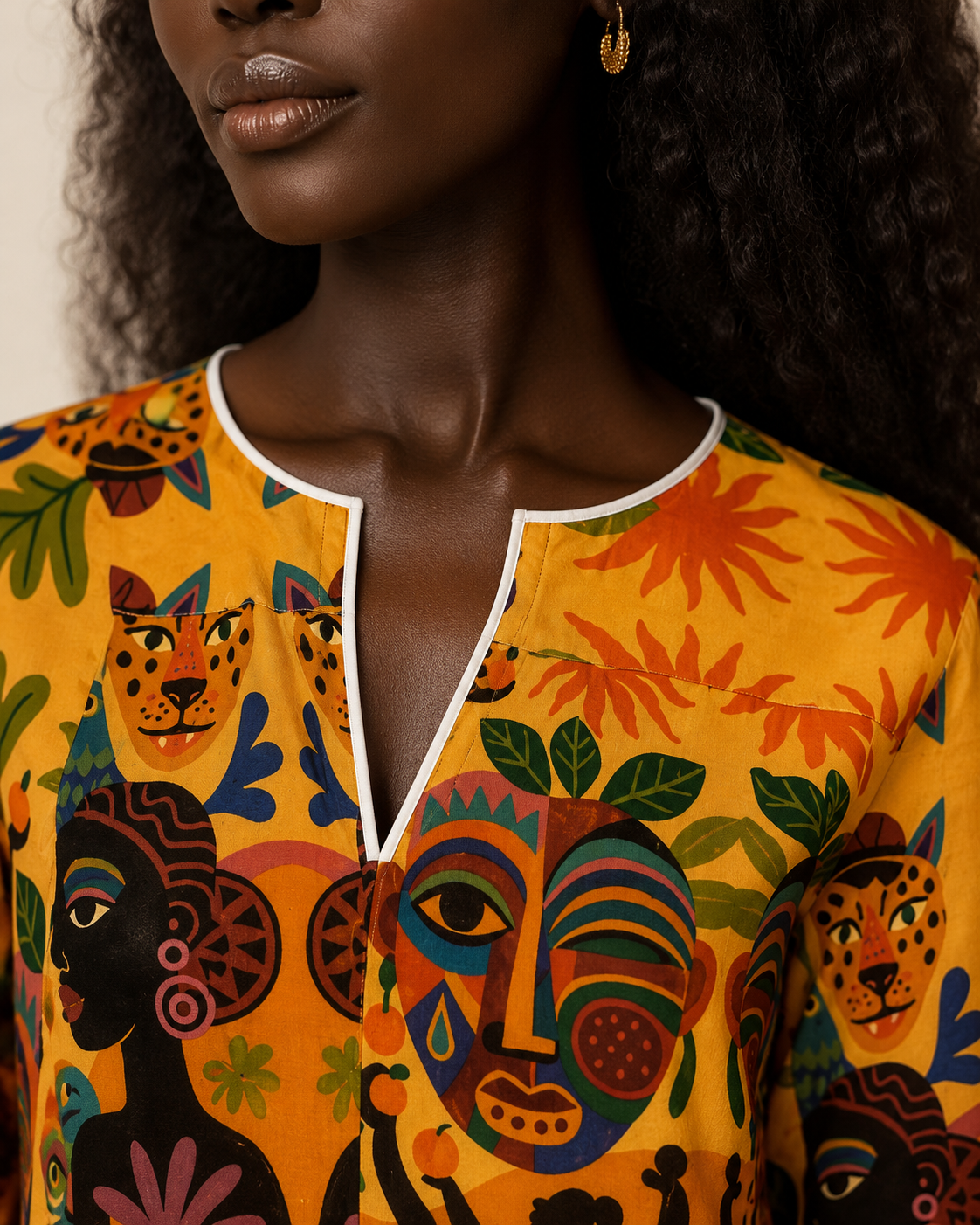 Gros plan sur l’encolure ronde et l’ouverture en V de la Blouse Tanéa. Le passepoil blanc souligne avec précision les finitions élégantes de cette création.