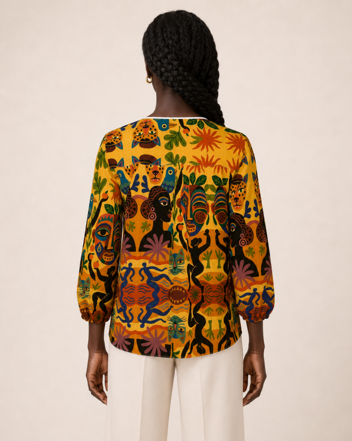 Vue de dos de la Blouse Tanéa portée par une mannequin. Le visuel met en valeur la ligne des épaules, les manches trois-quarts et le tombé fluide du vêtement.