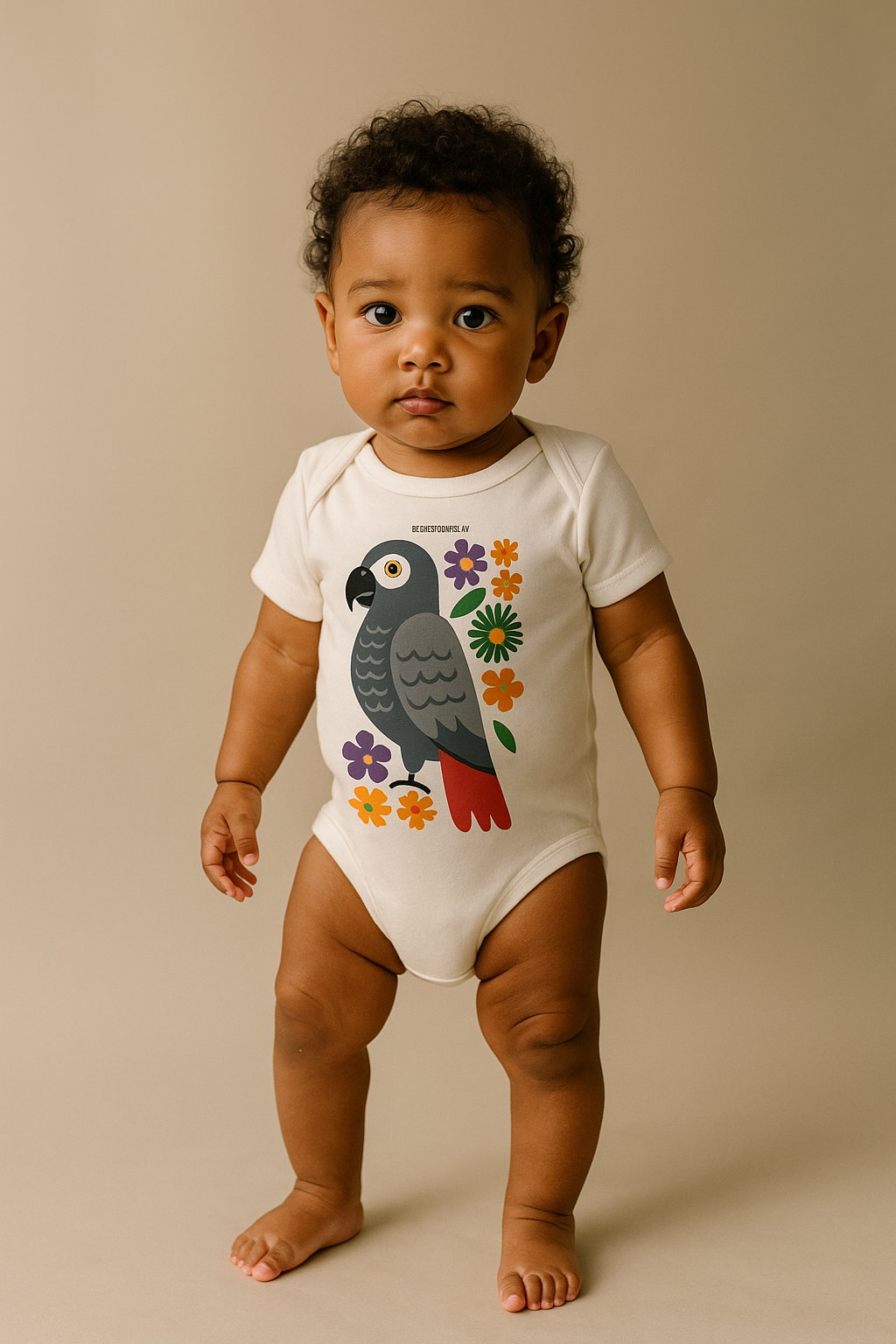 Bébé africain de 6 mois debout, portant le body blanc en coton bio Ndzéba, imprimé perroquet gris et fleurs colorées, studio photo mode afro luxe.