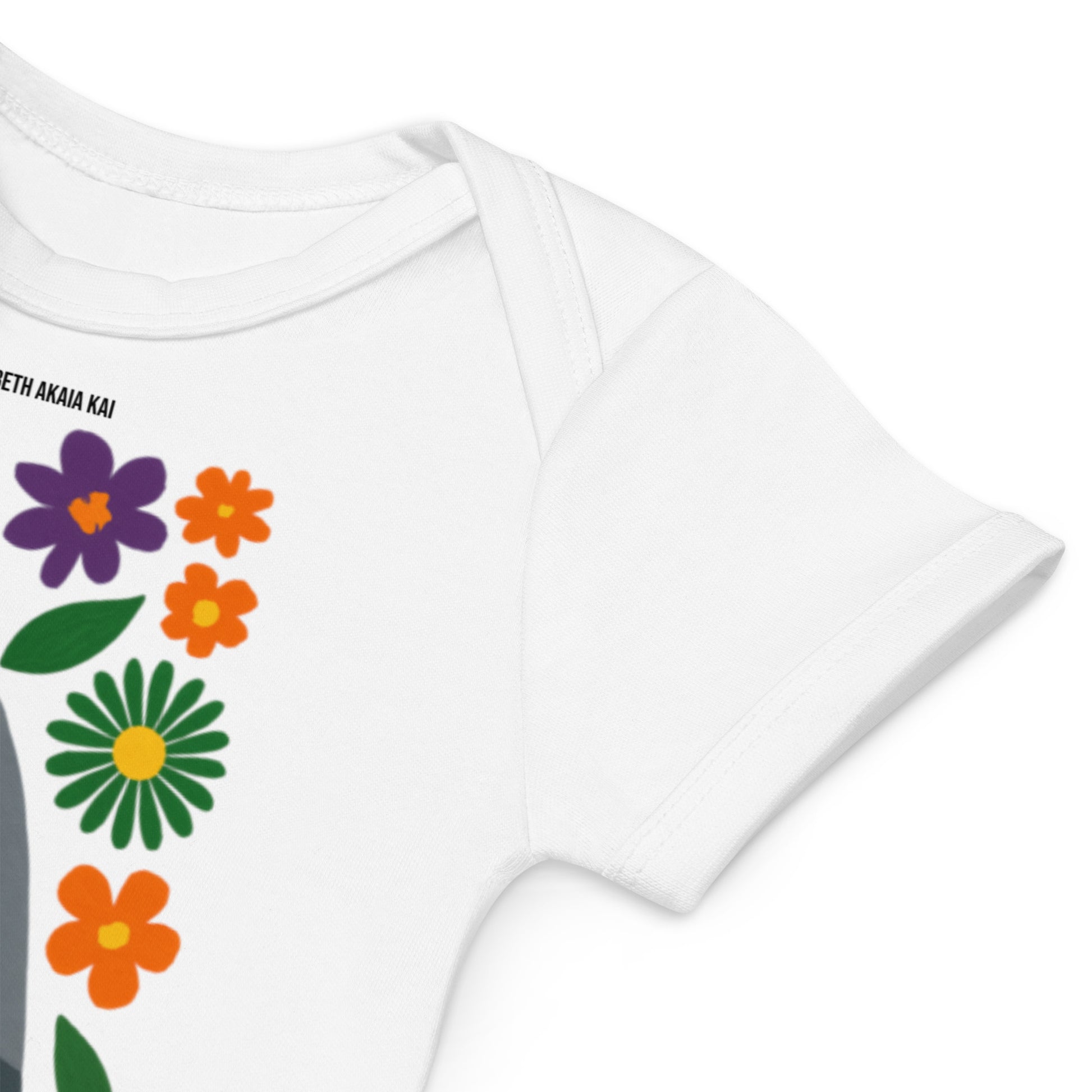 Gros plan sur la manche courte et l’encolure dégagée du body bébé Ndzéba, conçu pour le confort des enfants et l’élégance de la mode afro luxe.
