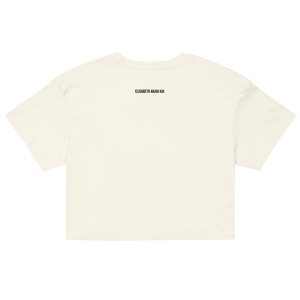 Crop top blanc Zoraya avec illustration colorée d’une femme et d’un félin sous un soleil, entourés de végétation – mode éthique et artistique
