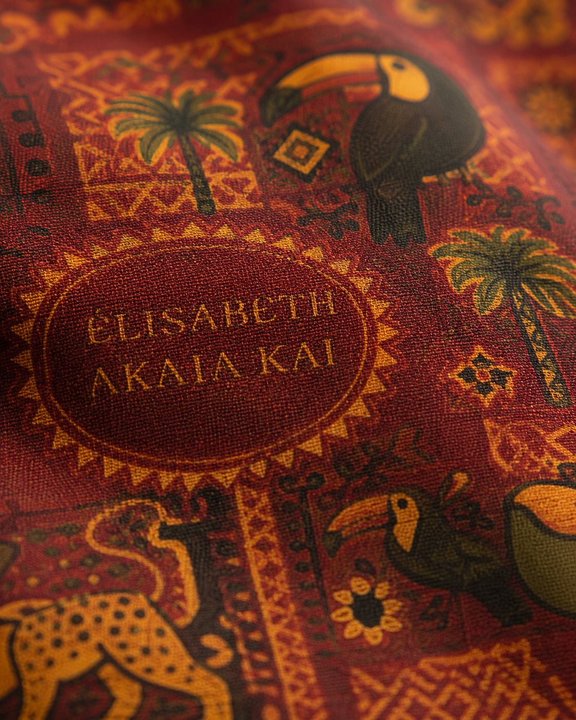 Gros plan sur la finesse du coton imprimé Palma Aurea. Cette photographie révèle la qualité du tissage, la précision des détails graphiques et l'intensité des couleurs, témoignant du savoir-faire de la Maison Élisabeth Akaïa Kaï.