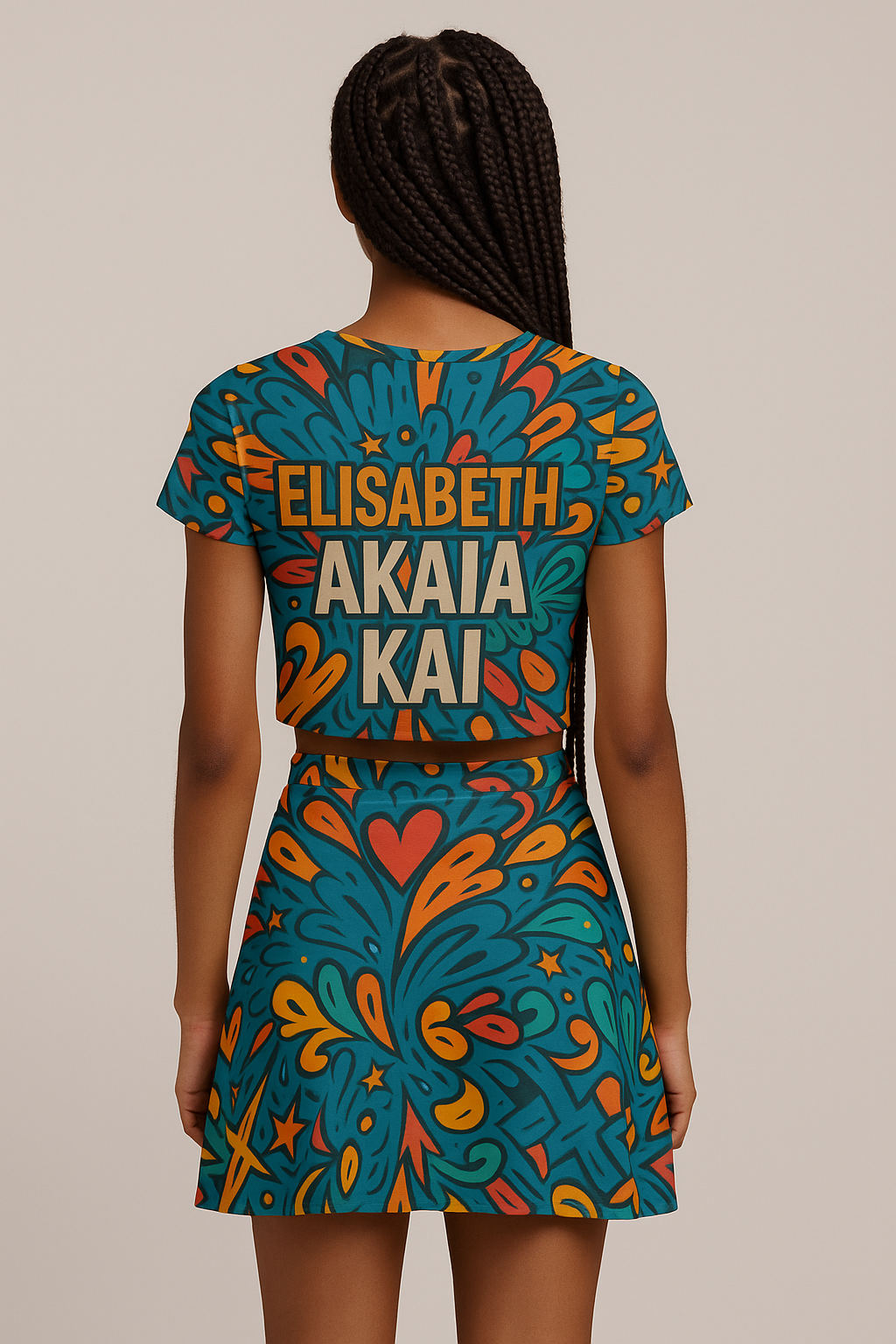 Texte alternatif (alt text) :
Vue arrière d’une mannequin afro avec des tresses, portant l’ensemble Afro Pop Libreville d’Élisabeth Akaïa Kaï : crop-top imprimé “ELISABETH AKAIA KAI” et jupe patineuse courte assortie, imprimé artistique all over aux couleurs vives, photographie de mode en studio sur fond neutre, style afro-luxe.