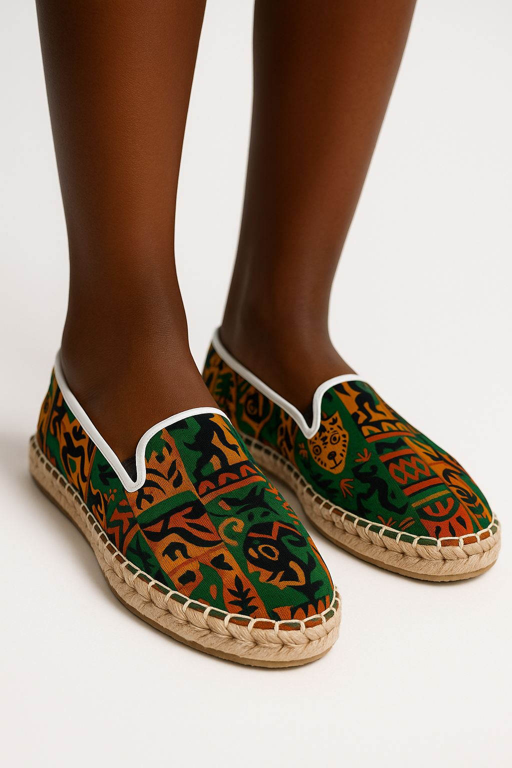 Espadrilles de luxe Nzinga portées, photographie de profil en studio, détails visibles de la semelle tressée et du motif artistique afro inspiré de rituels solaires.