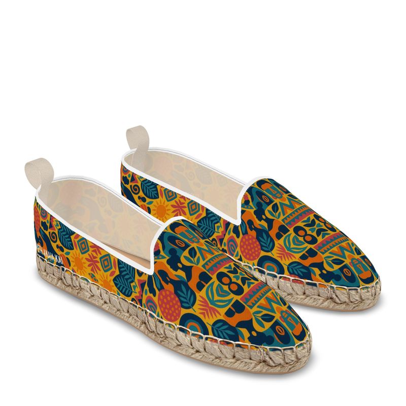 Paire d’espadrilles mocassins Zamaïa à imprimé artistique multicolore, fond jaune et bleu, semelle en corde naturelle, sur fond blanc.