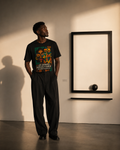 Homme noir portant le t-shirt Les Grandes Gueules du Gabon dans une galerie d’art contemporaine, création afro luxe Élisabeth Akaïa Kaï.