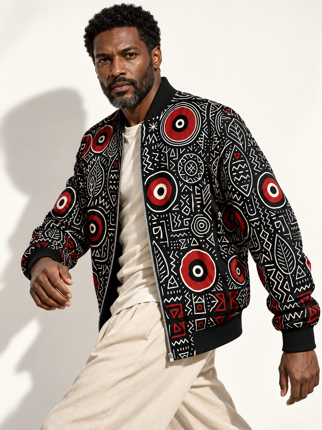 Veste bomber MUBÈNI portée ouverte sur un t-shirt écru par un mannequin en mouvement. Création de mode gabonaise contemporaine signée Élisabeth Akaïa Kaï.