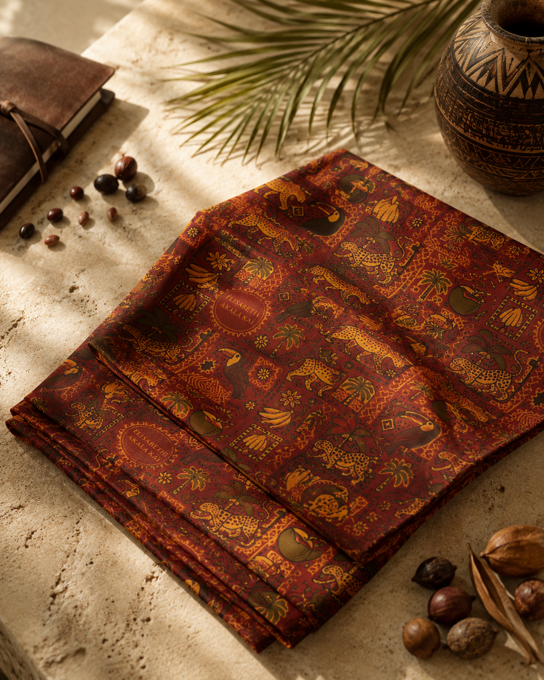 Le pagne Palma Aurea est présenté délicatement plié afin de mettre en valeur la richesse de son motif exclusif. Une composition inspirée des ateliers de création où chaque détail célèbre l'art textile contemporain.
