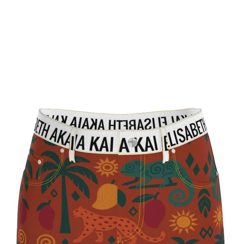 Femme portant une jupe longue en denim imprimé tropical, fendue à l’avant, ceinturée de blanc, dans un décor lumineux et naturel.