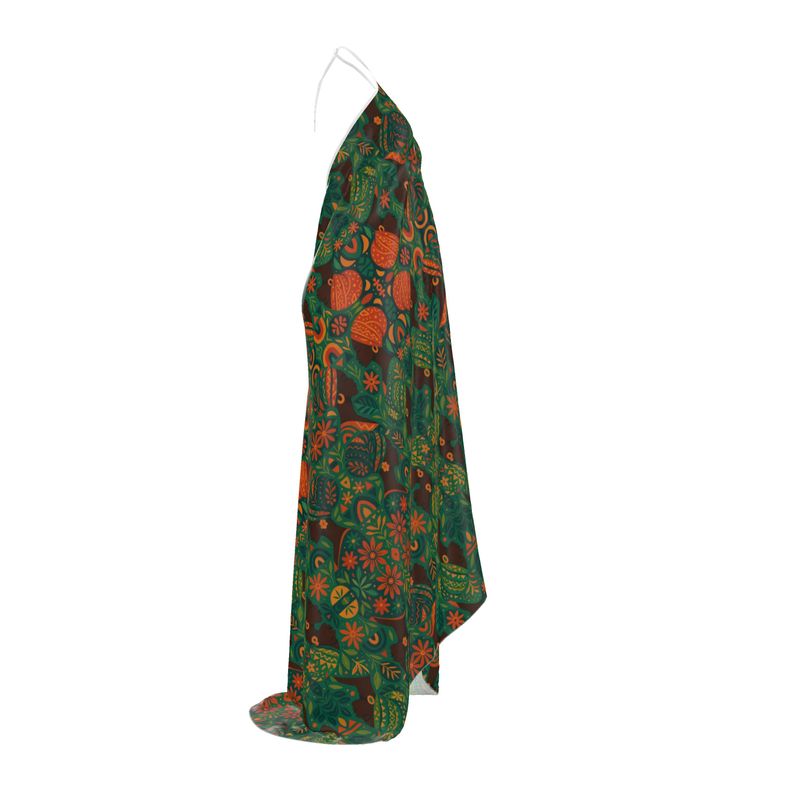 Mannequin matte de peau portant la robe longue dos-nu Dzanaï à imprimé floral tropical dans un décor végétal, création artistique et éthique signée Élisabeth Akaïa Kaï