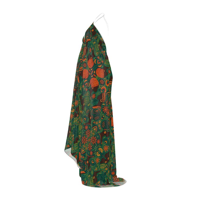 Mannequin matte de peau portant la robe longue dos-nu Dzanaï à imprimé floral tropical dans un décor végétal, création artistique et éthique signée Élisabeth Akaïa Kaï