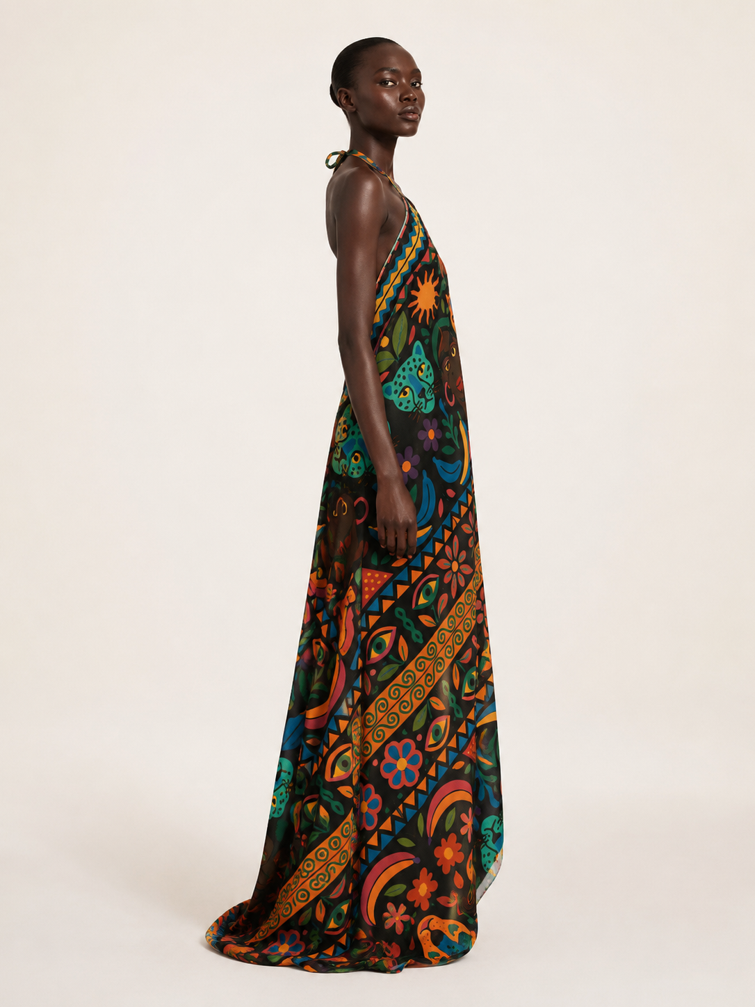 Vue latérale de la Robe dos nu Okouméa montrant sa coupe ample, sa longueur au sol et la continuité de son motif coloré.