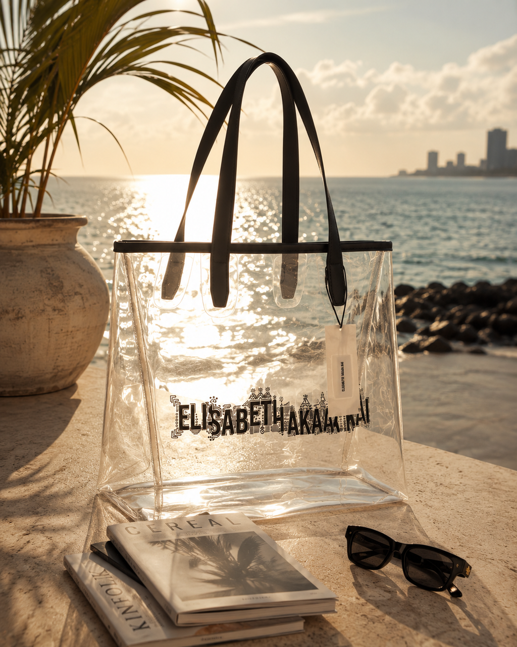 Le sac cabas transparent Elisabeth Akaia Kai illumine une scene face a l'ocean Atlantique. Une photographie lifestyle de luxe inspiree de Libreville, entre elegance contemporaine et evasion.
