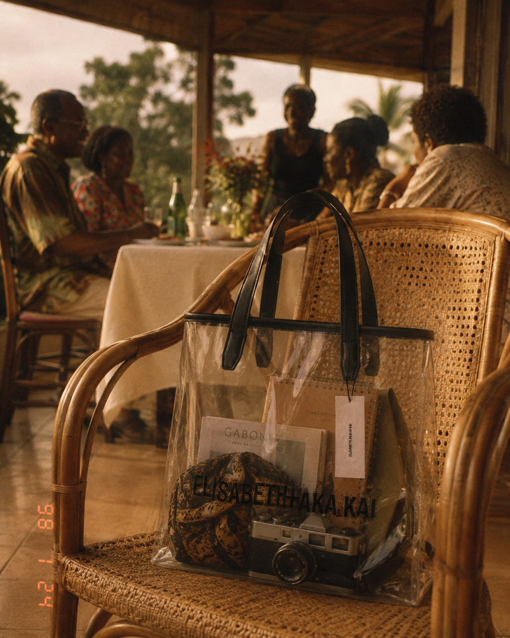Le sac cabas transparent Elisabeth Akaia Kai evoque les souvenirs de famille et les voyages au Gabon. Une photographie inspiree de l'argentique qui celebre le luxe emotionnel et les instants precieux.