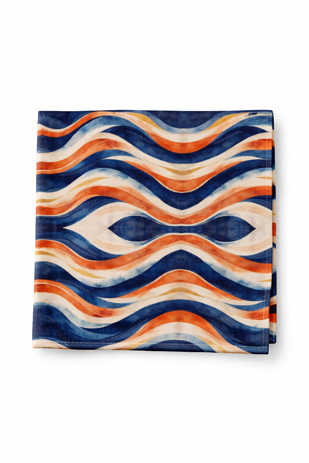 Photographie objet d’une serviette de table 40 × 40 cm au motif Mbyela, ondulations solaires aux tons bleu profond, terracotta et sable, présentée sur fond blanc en format vertical, art de la table design et luxe contemporain d’inspiration afro.