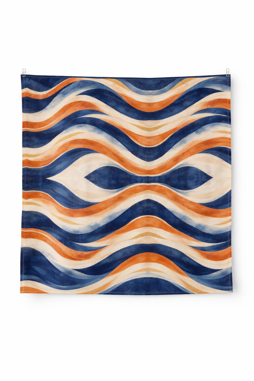 Photographie d’objet sur fond blanc d’une serviette de table Mbyela 40 × 40 cm, entièrement dépliée et suspendue, mettant en valeur le motif ondulations solaires aux teintes bleu profond, terracotta et sable, art de la table design et contemporain.