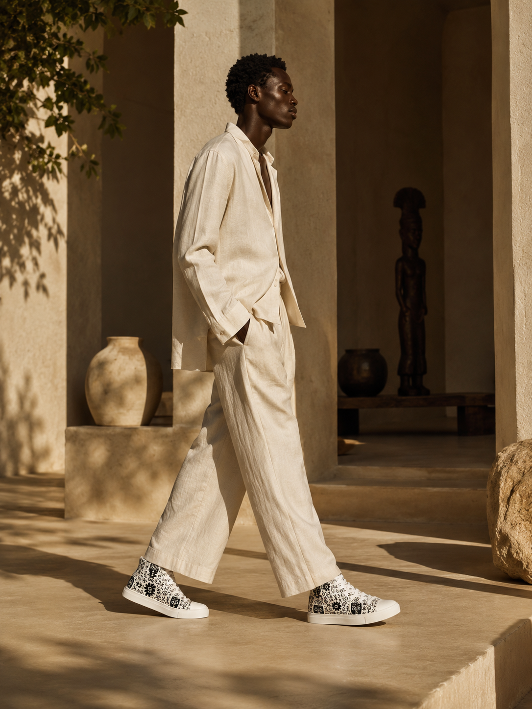 Portées dans un décor architectural minimaliste baigné de lumière solaire, les sneakers IKARÉ incarnent une élégance fluide entre Afrique contemporaine et art de vivre méditerranéen.