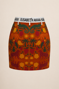 Photographie e-commerce premium de la jupe courte Élisabeth Akaïa Kaï sur fond ivoire. Une vue de face permettant d'apprécier la coupe, les finitions et les motifs exclusifs.