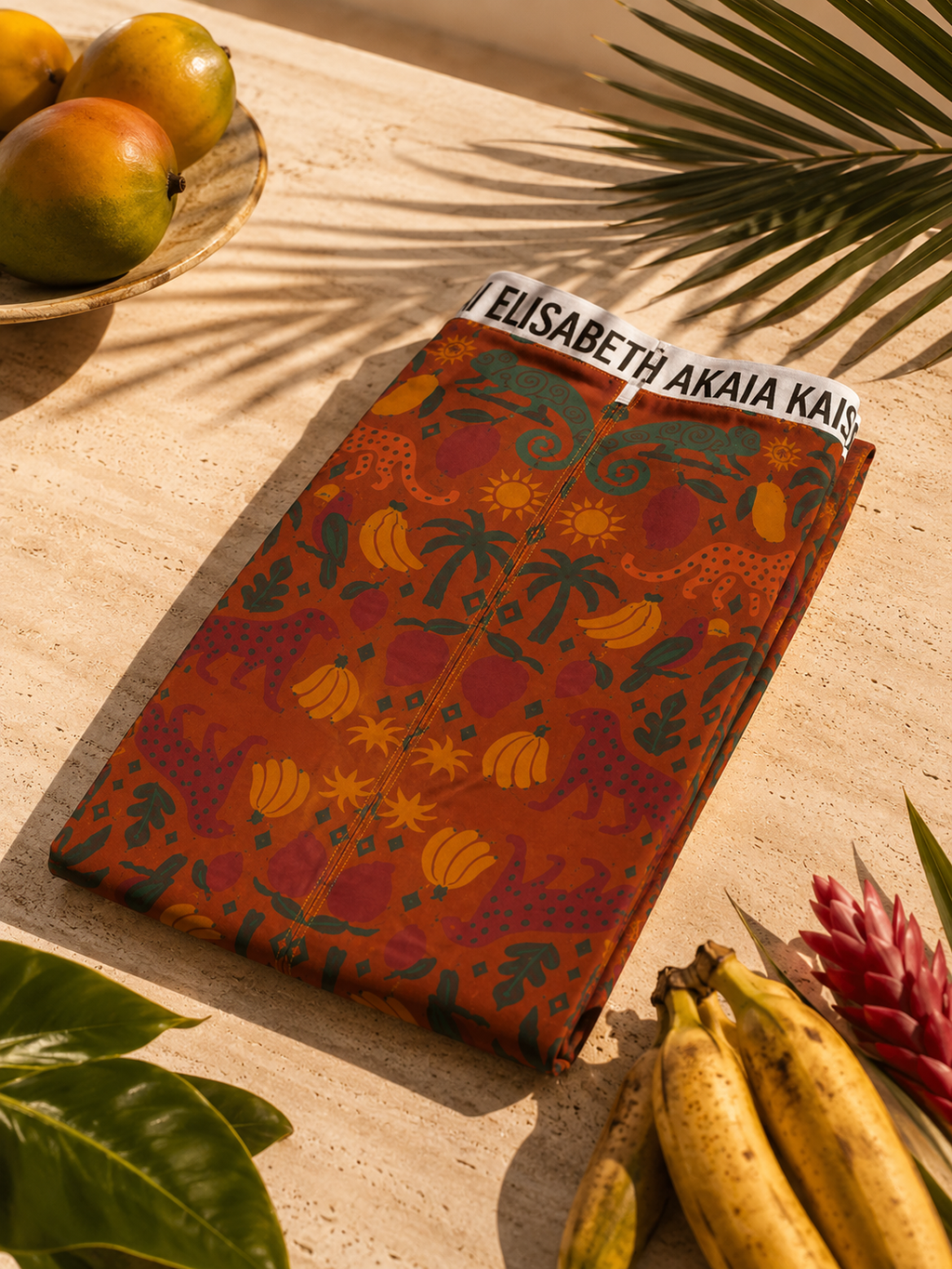 Nature morte éditoriale mettant en scène la jupe Élisabeth Akaïa Kaï entourée de fruits et de feuillages tropicaux.