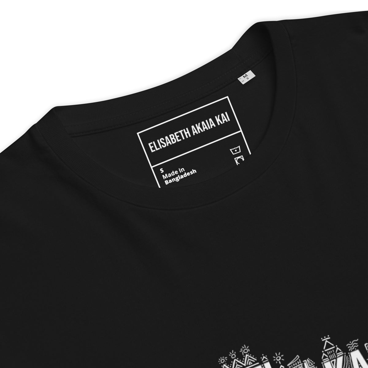 Gros plan sur le col rond et l'étiquette intérieure Élisabeth Akaïa Kaï du t-shirt KAÏ noir.