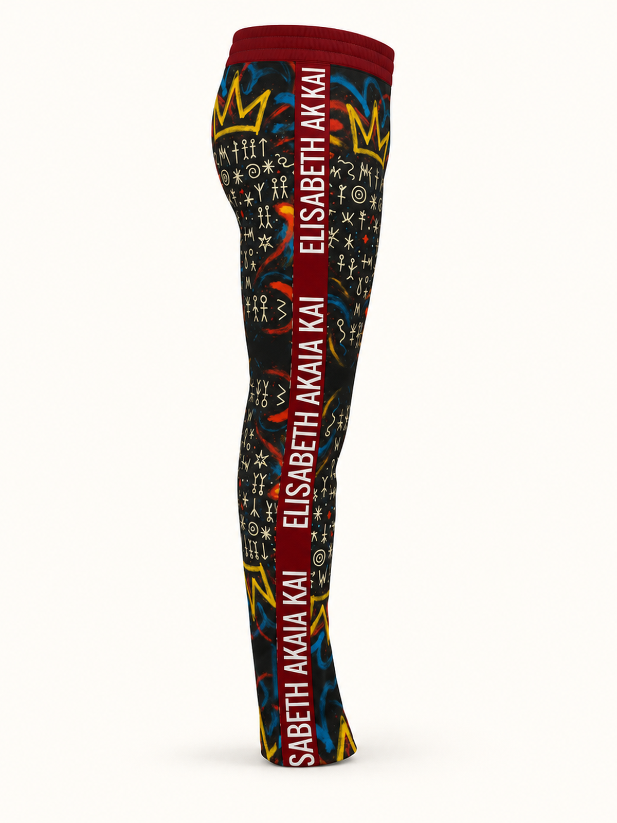 Vue de profil du jogging homme MIENGO SEKIANI, motifs graphiques et bande latérale bordeaux siglée Élisabeth Akaïa Kaï.