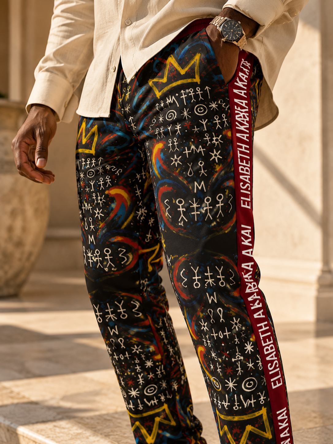 Gros plan sur l'imprimé graphique du pantalon MIENGO SEKIANI et sa bande bordeaux portant le nom Élisabeth Akaïa Kaï.