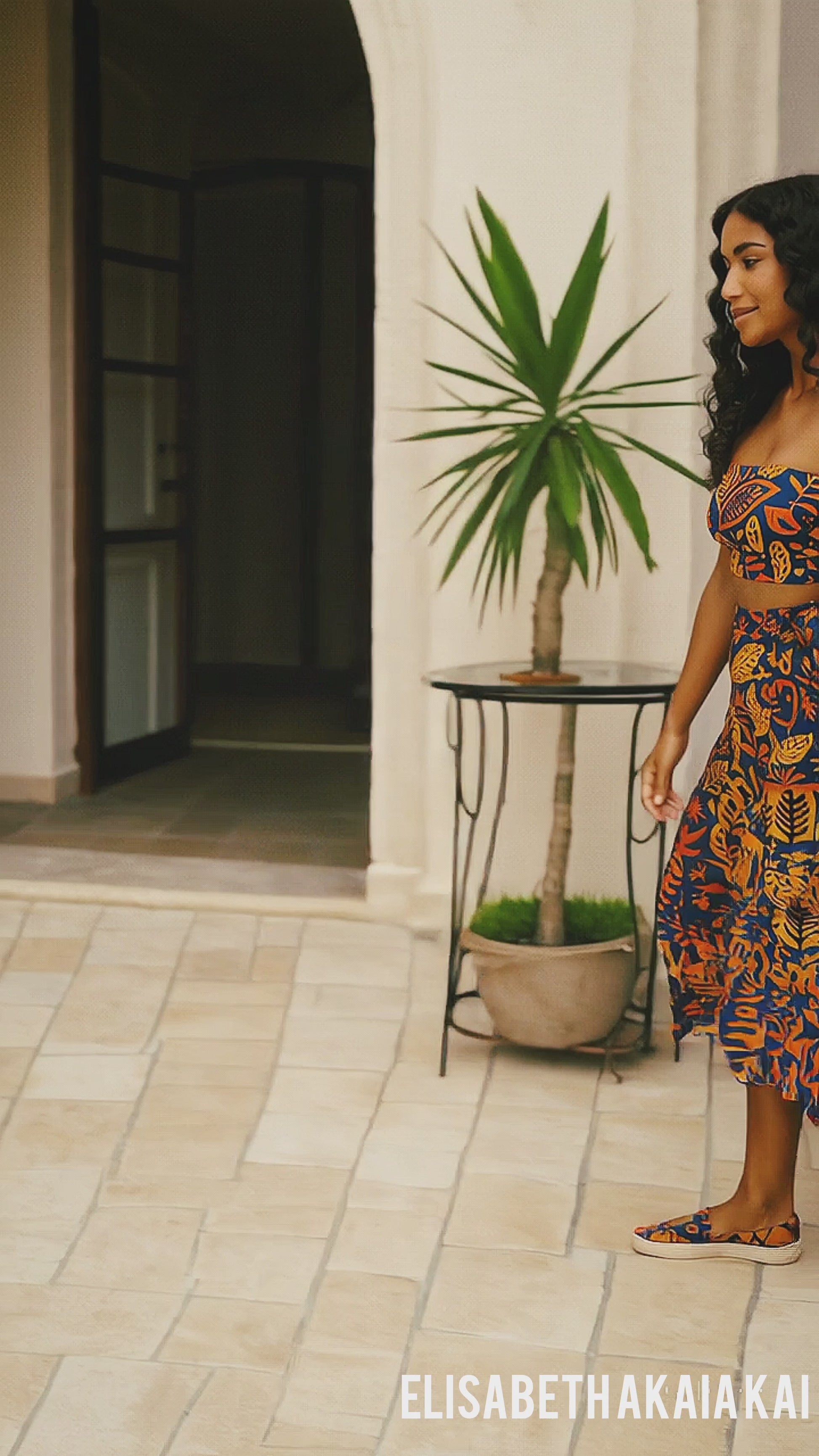 Vidéo de campagne mode mettant en scène une femme élégante portant le bandeau Isla Sol dans une villa méditerranéenne. La scène met en valeur un look estival chic avec imprimé tropical, jupe fluide et espadrilles assorties. Lumière dorée, ambiance solaire et esthétique luxe.